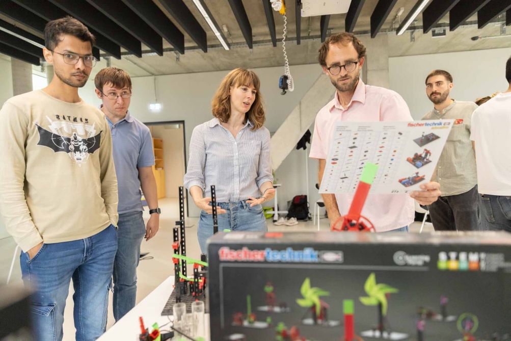 Studierende stehen nebeneinander und besprechen ein Projekt