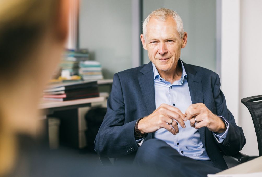 Ein Mann sitzt auf einem Stuhl und erzhlt einer anderen Person etwas