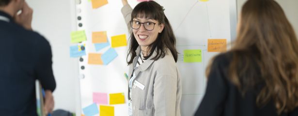 Frau vor einer Wand mit angepinnten farbigen Moderationskarten