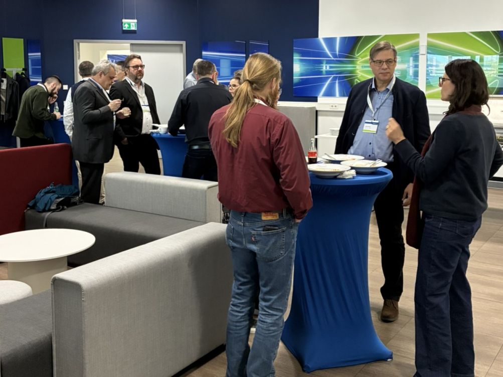 Personen unterhalten sich an Stehtischen