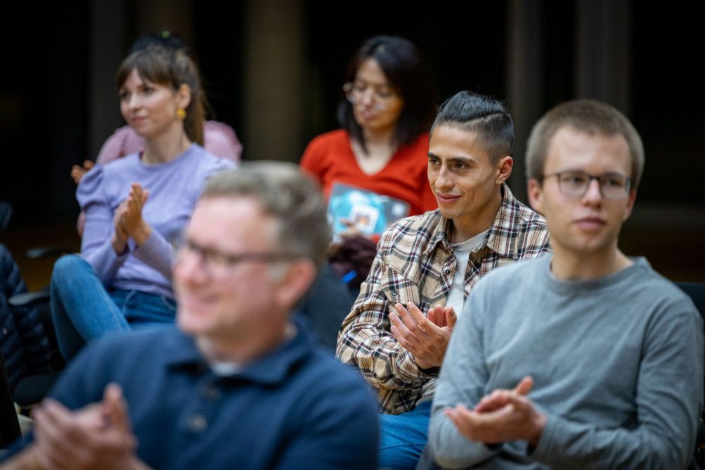 Studierende applaudieren bei einer Veranstaltung
