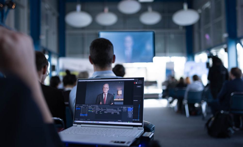Aufgeklappter Laptop spielt Präsentation in einem Saal ab