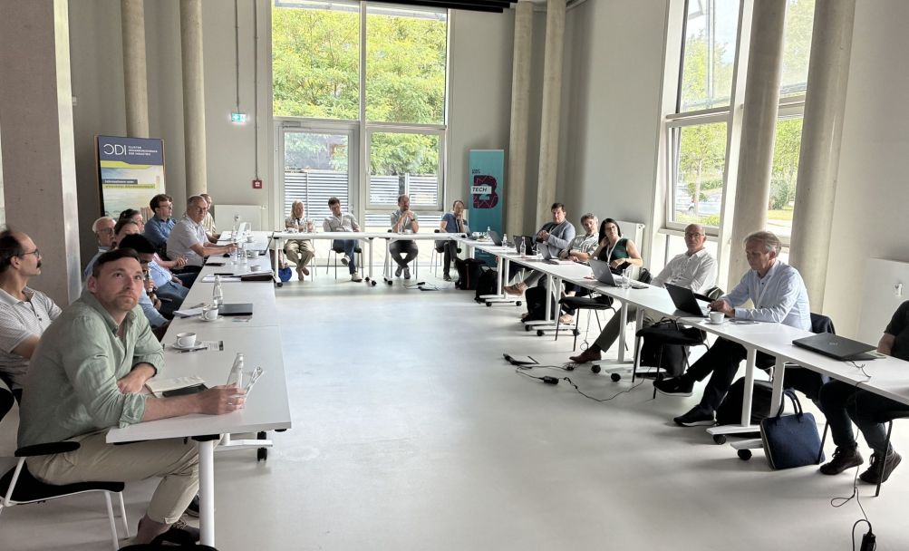 Menschen an U-förmigem Konferenztisch