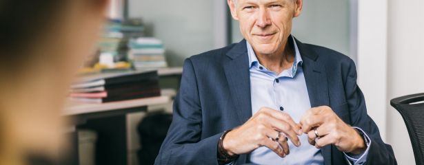 Ein Mann sitzt auf einem Stuhl und erzhlt einer anderen Person etwas